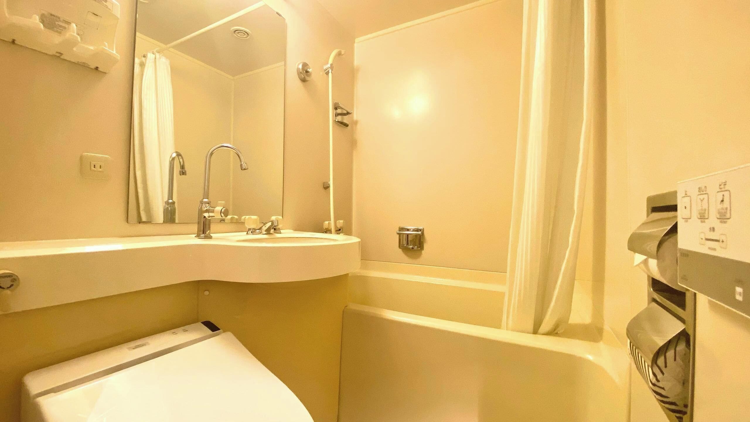 Un baño con lavamanos, espejo, ducha e inodoro.