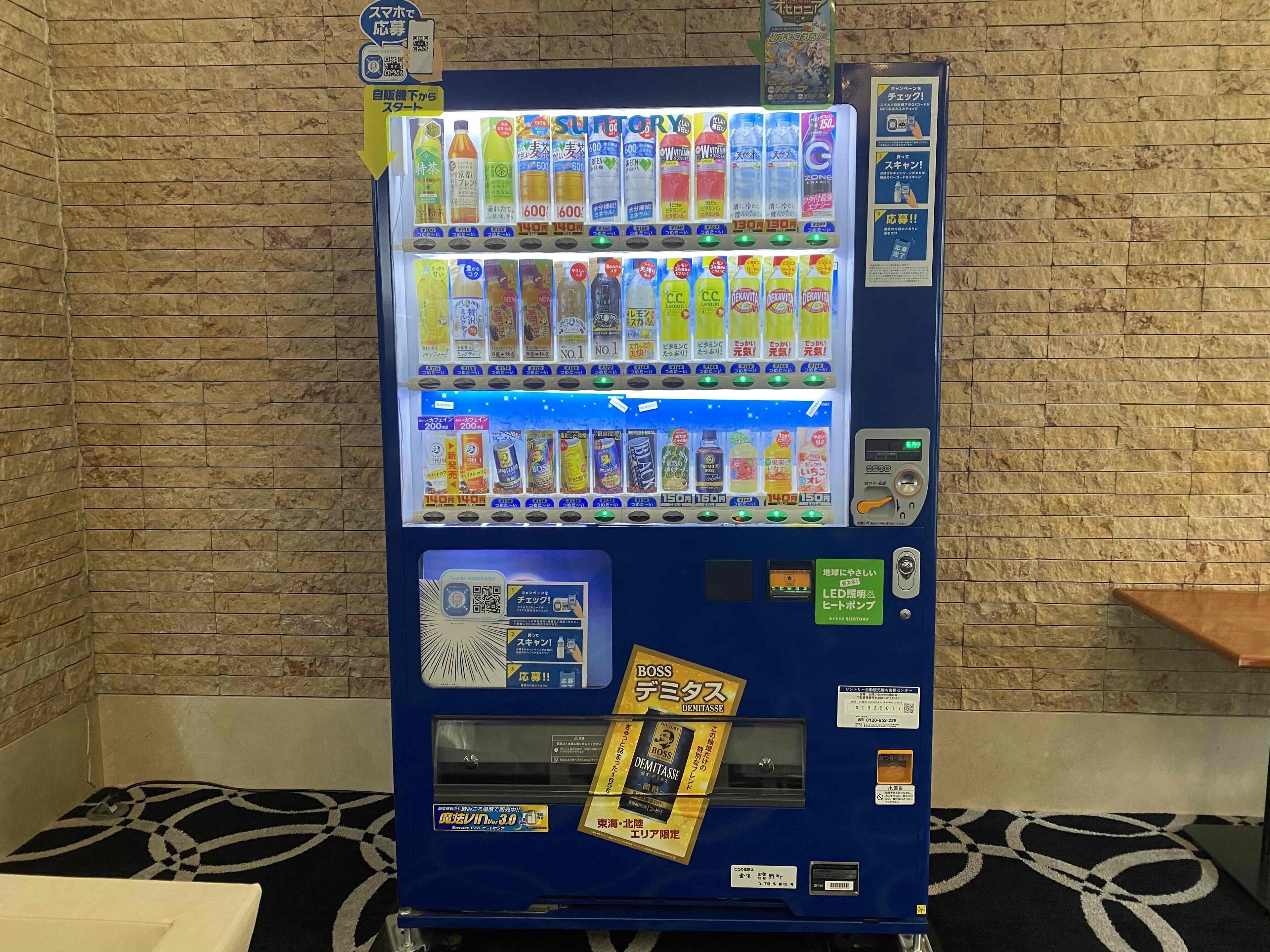 A vending machine with various drinks and snacks, a QR code, and a payment terminal.