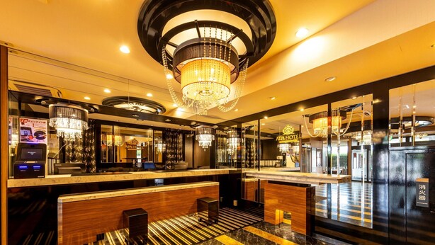Eine Hotelhalle mit einer Rezeption, einer Kandelaber und einem Check-in-Schalter.