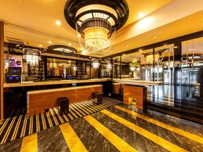 Een hotel lobby met een receptiebalie, een kroonluchter en een incheckplein.