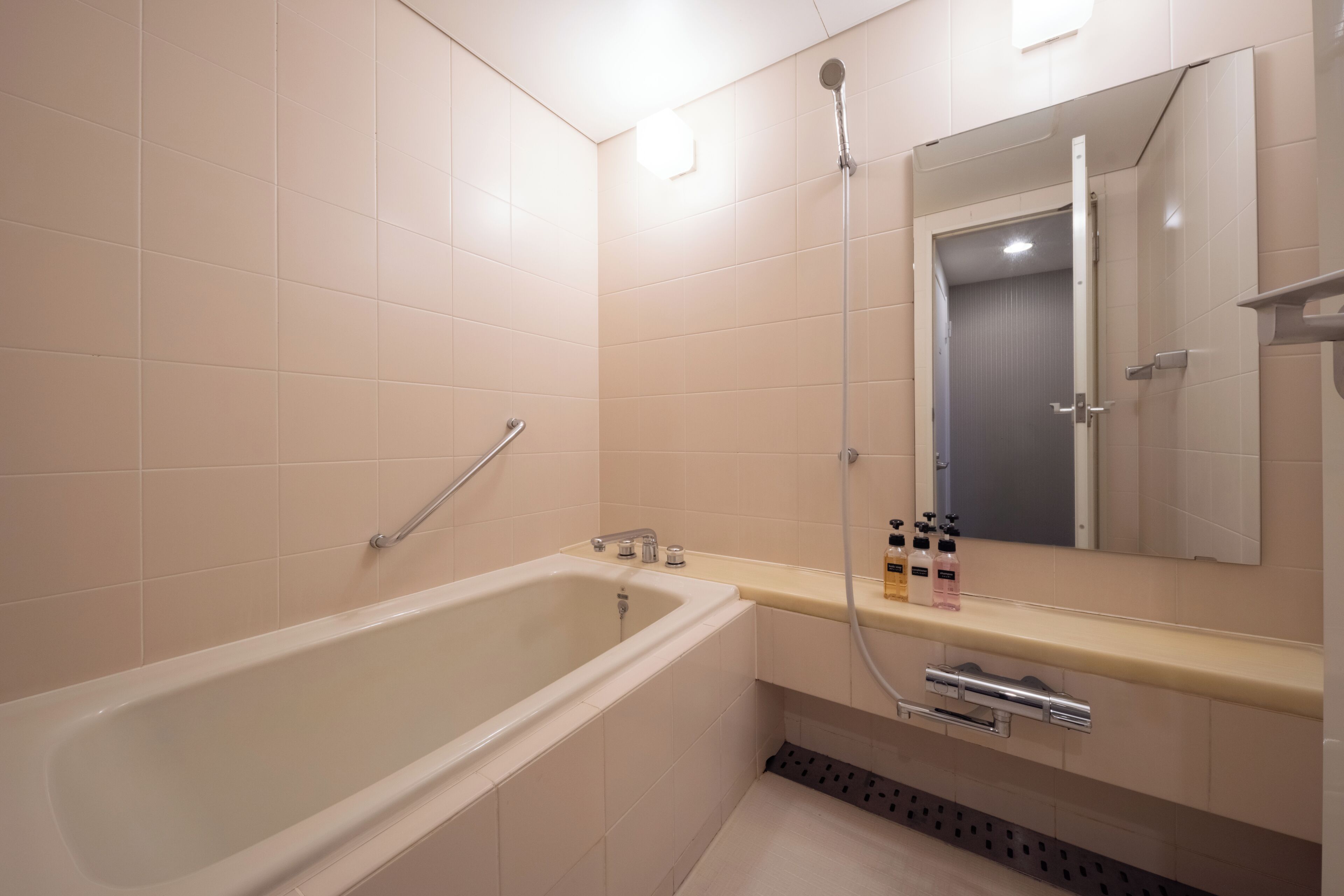 Un bagno moderno con una vasca da bagno, una doccia, un lavabo con specchio e un water.