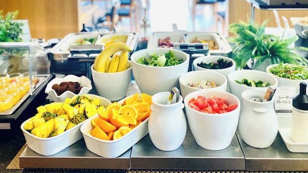 Un bufé con una variedad de alimentos, incluyendo frutas, ensaladas y otros platos.