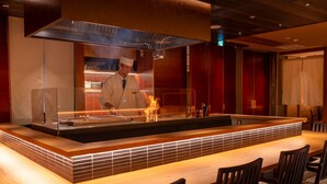 Un restaurant moderne doté d’un îlot central, de tables et de chaises en bois.