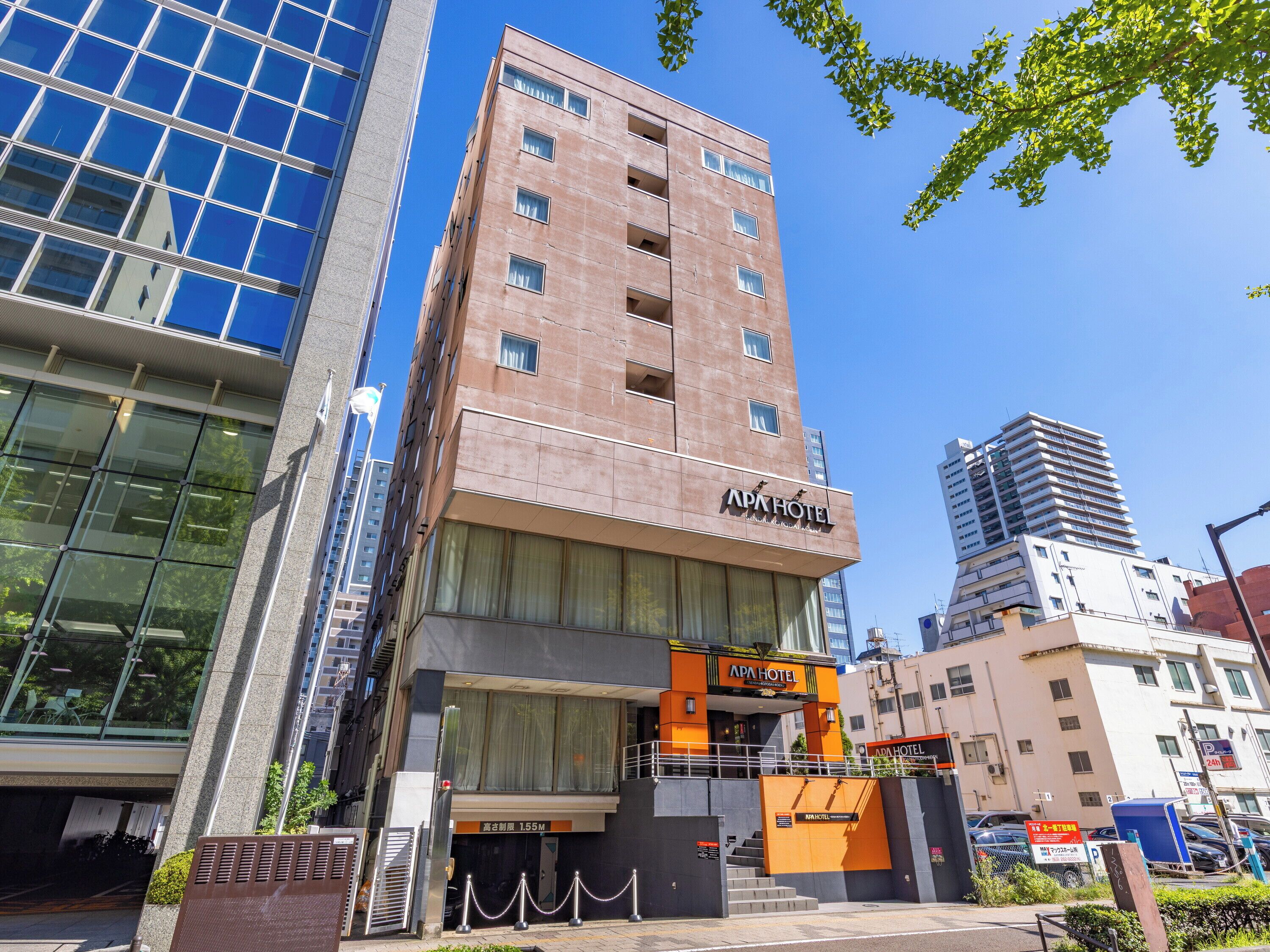 A hotel with a modern facade, large windows, and a visible entrance with a sign.