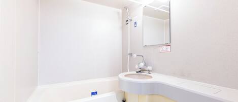 A bathroom with a bathtub, a sink, a mirror, and a showerhead.