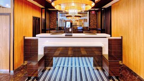 A hotel reception area with a modern design, featuring a reception desk, a chandelier, and a check-in counter. - APA Hotel Sendai Kotodai Koen (Sendai)