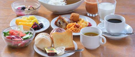 A table with various breakfast items including cereal, toast, fruit, and beverages.