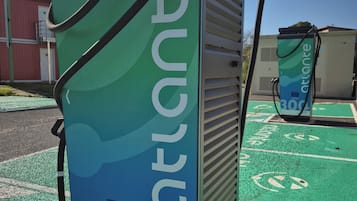 Uma estação de carregamento com design verde e azul, identificada como 'ATLANTE 300 kW'.