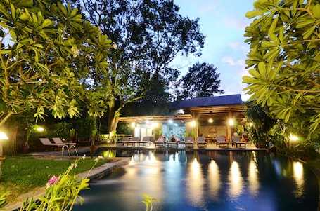 Una piscina al aire libre, sillones reclinables de piscina