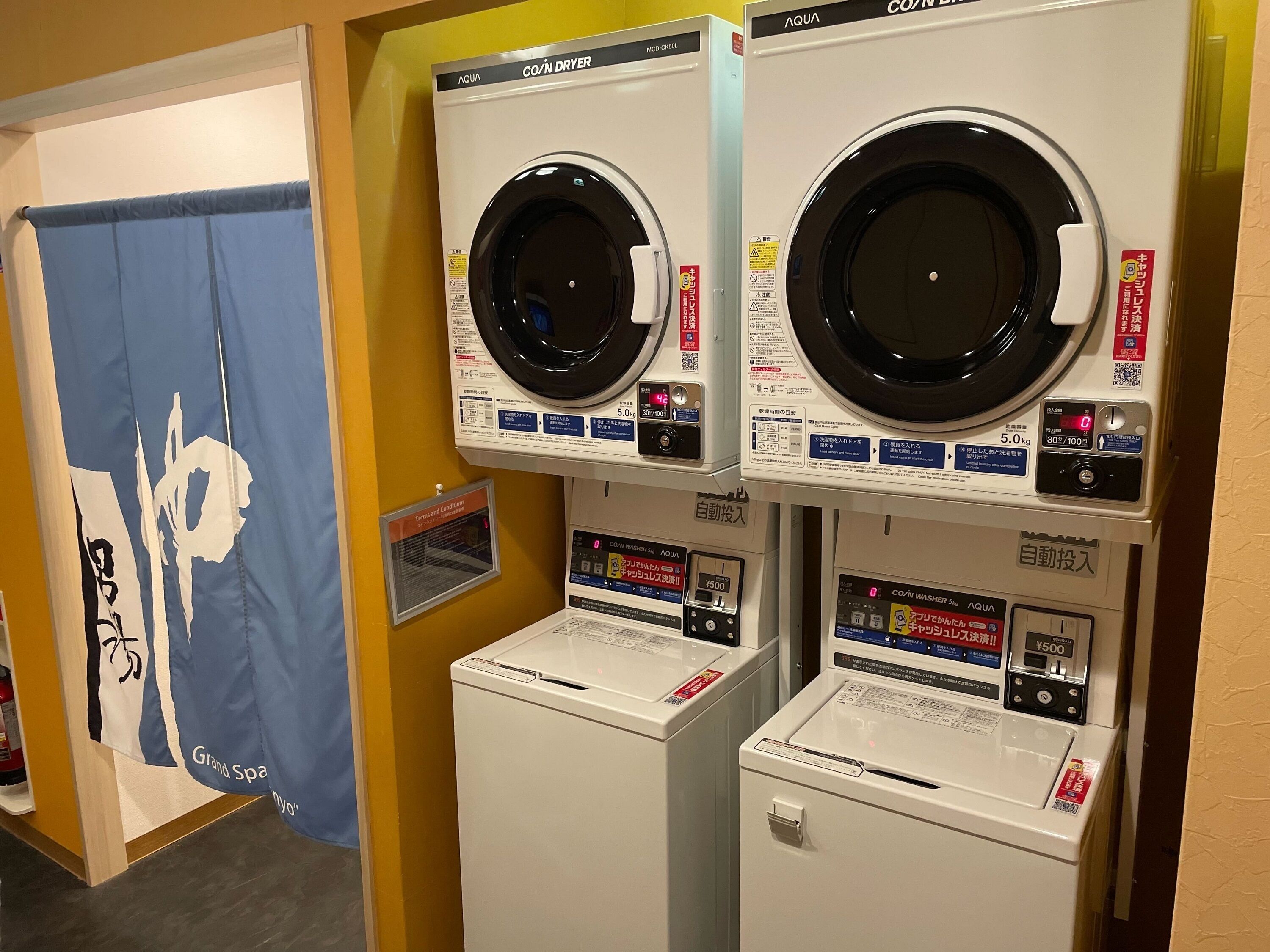 A laundromat with two front-loading washing machines and two dryers.