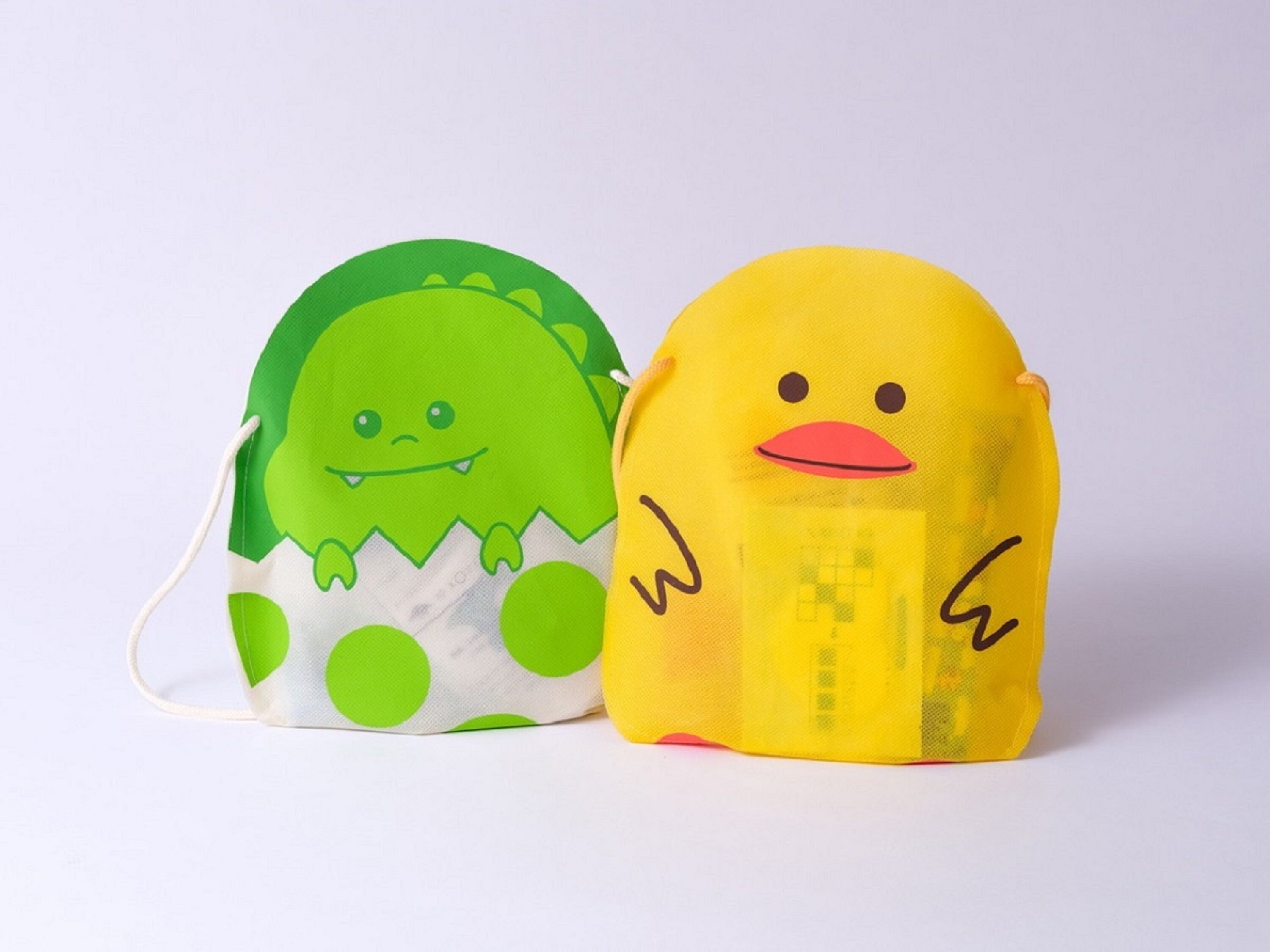 Two bags with cartoon faces, one green and one yellow.