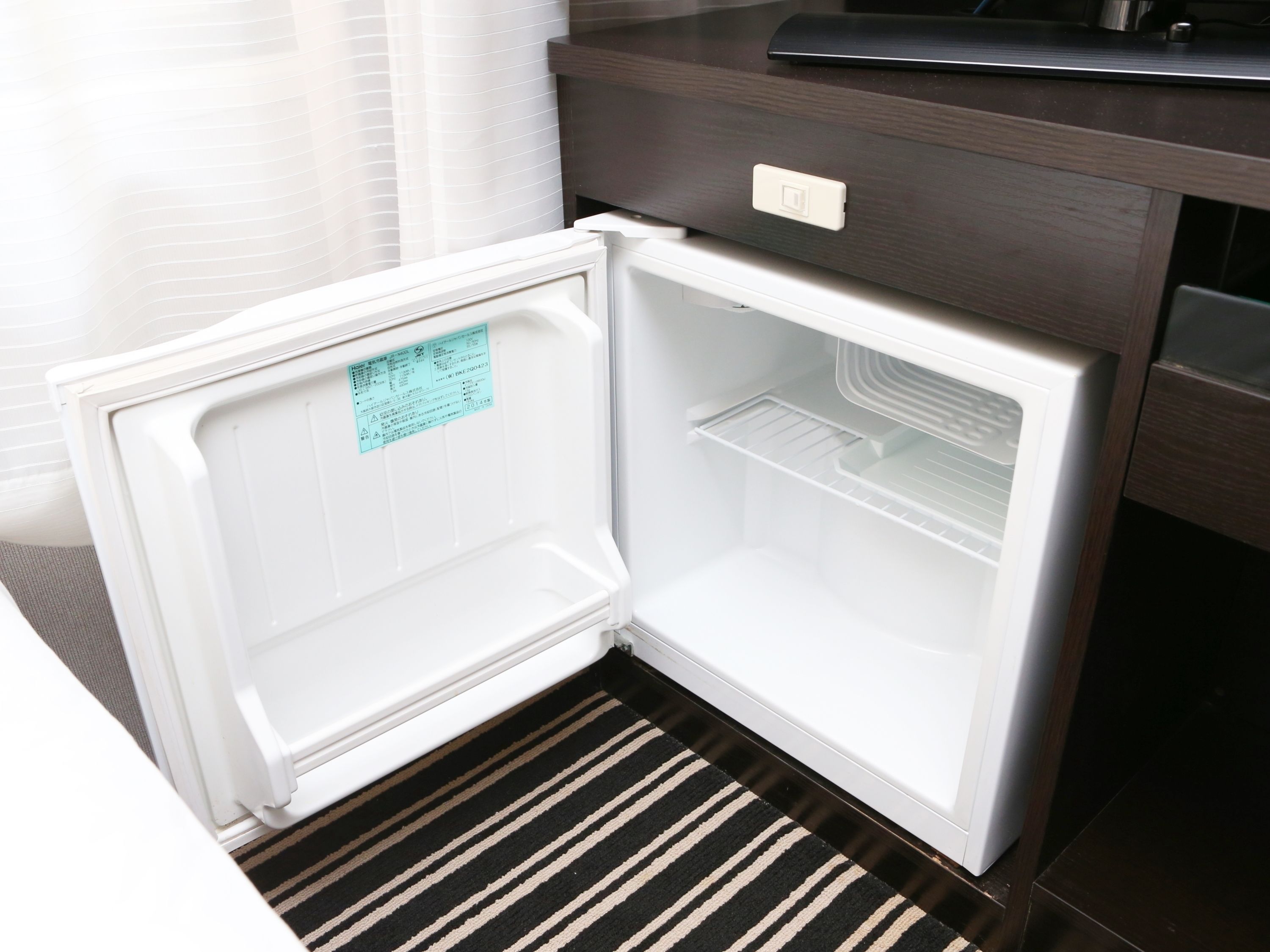 A white refrigerator with a control panel and a small label on the door.