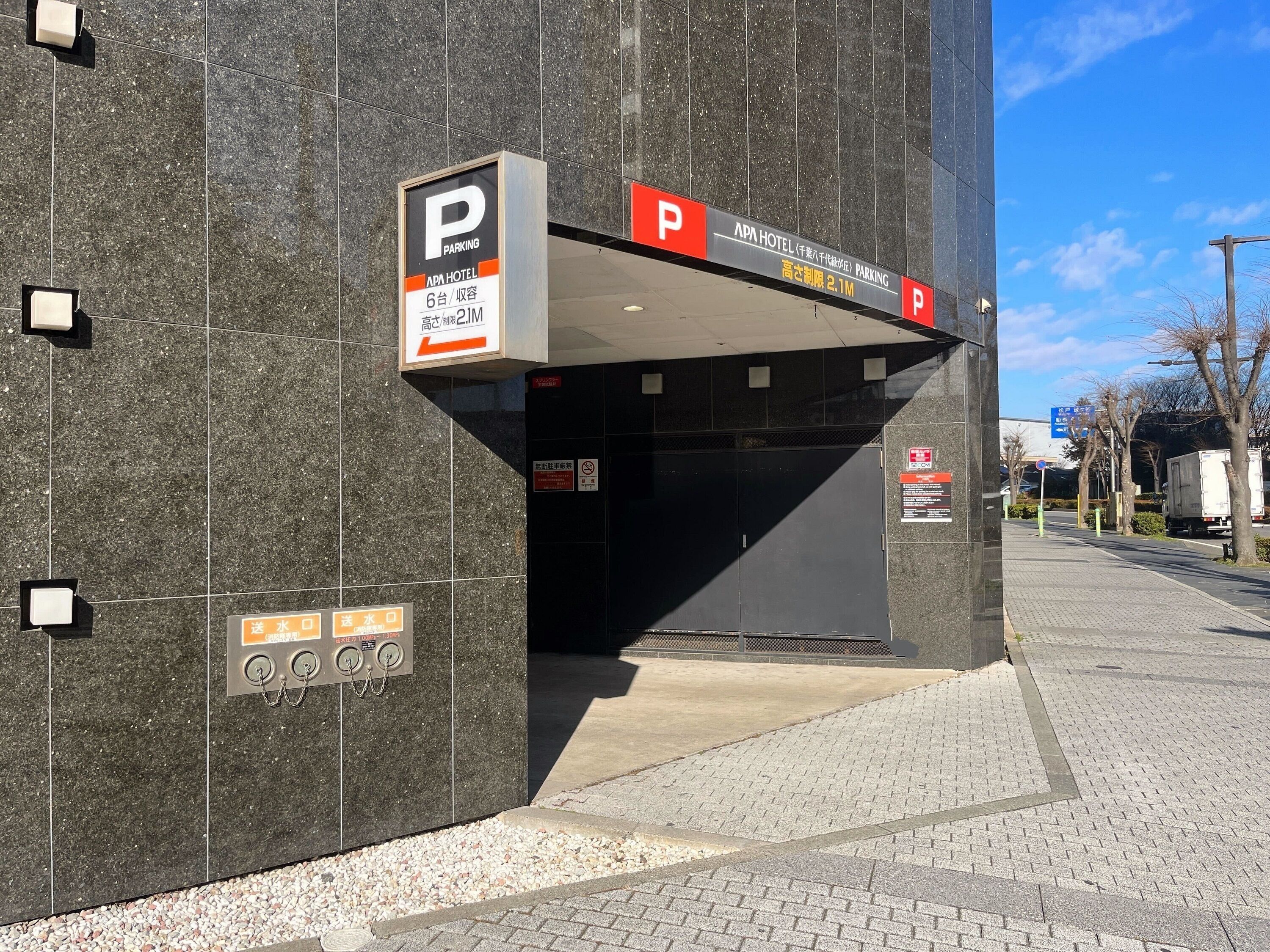 A parking structure with a sign indicating it is for APA Hotel.