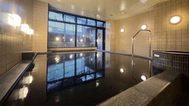 A modern indoor pool area with a glass wall, metal railings, and tiled walls. - APA Hotel Chiba Yachiyo Midorigaoka (Yachiyo)