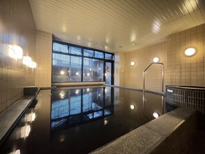 A modern indoor pool area with a glass wall, metal railings, and tiled walls. - APA Hotel Chiba Yachiyo Midorigaoka (Yachiyo)