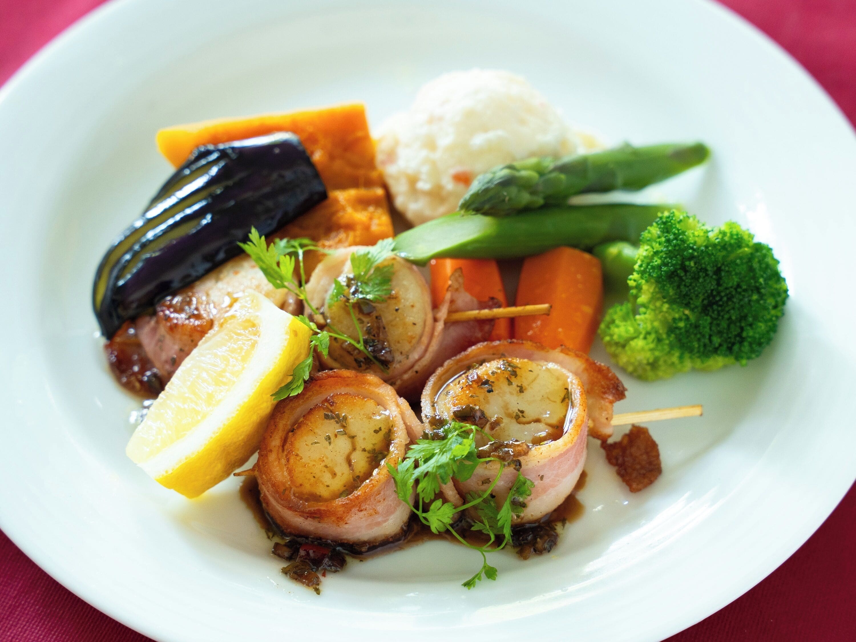 A plate of food with various vegetables and a piece of meat.
