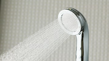 A showerhead with water flowing from it.