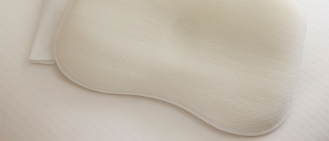 Un oreiller blanc et une taie d’oreiller blanche sur un lit blanc.