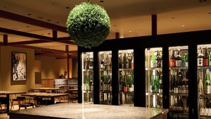 Un restaurant doté d’un îlot central, de tables en bois et d’une variété de bouteilles disposées en arrière-plan.