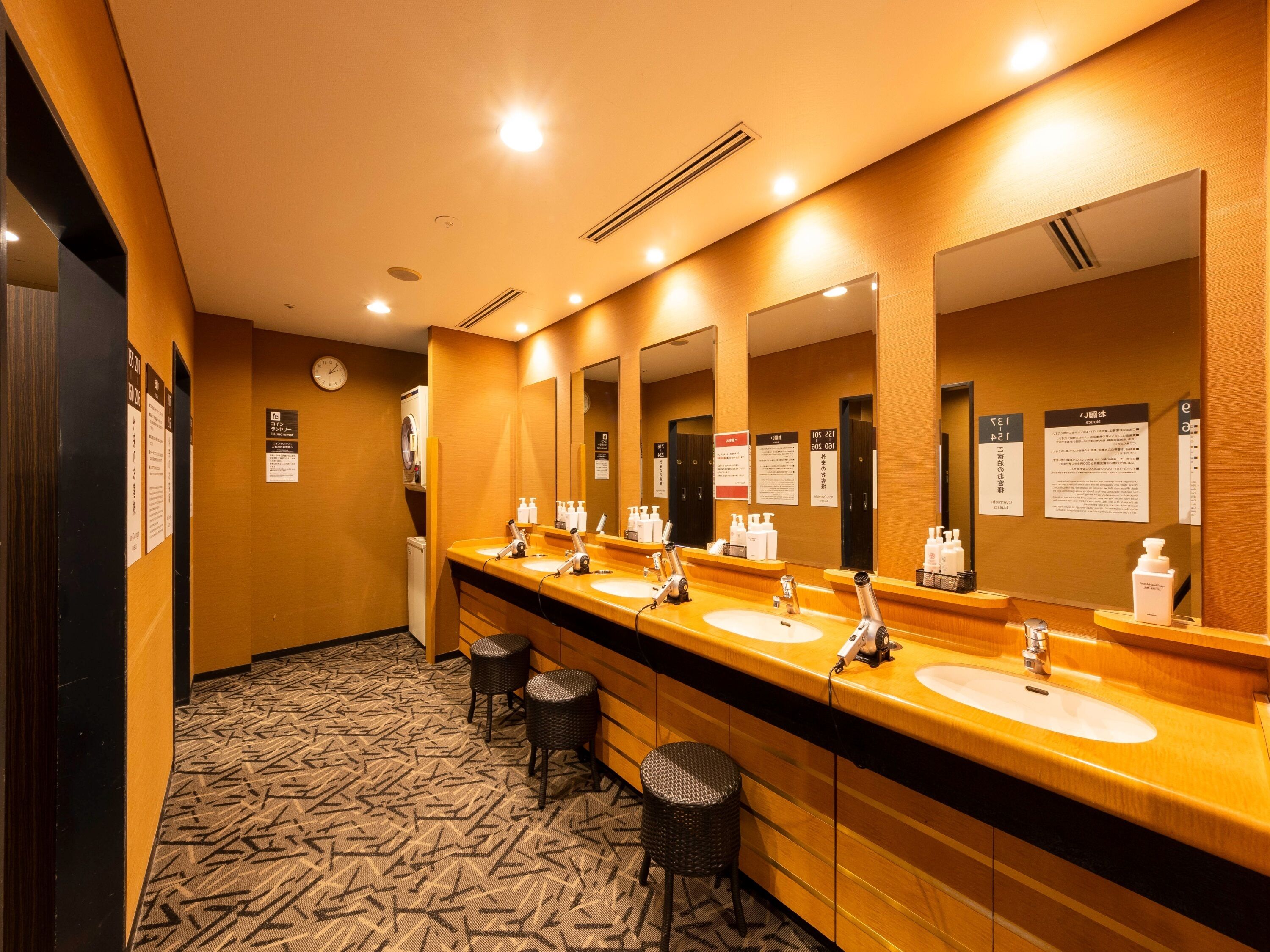 A hotel bathroom with multiple sinks, mirrors, and a patterned floor.