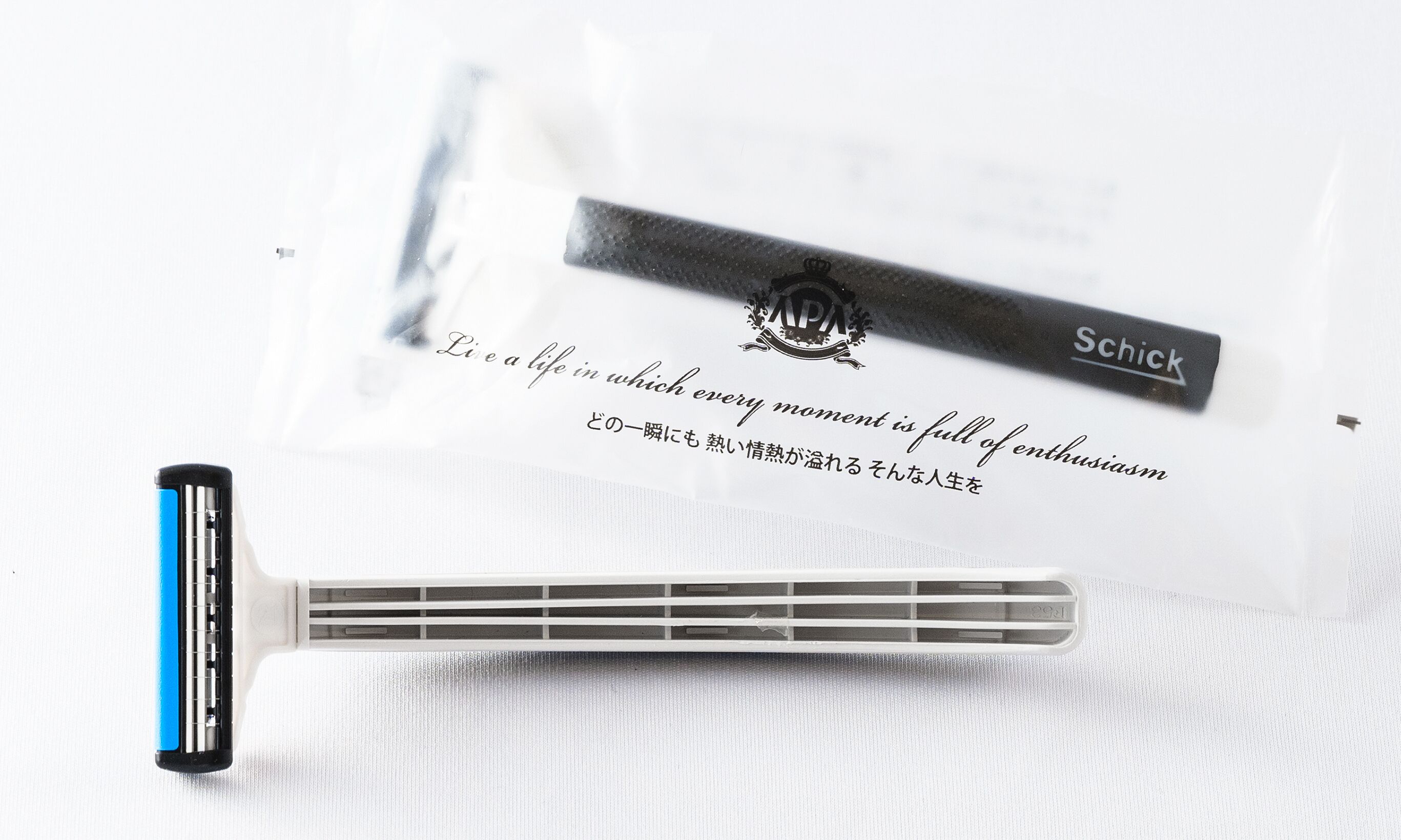 A razor, a Schick razor blade, and a packaging with Japanese text.