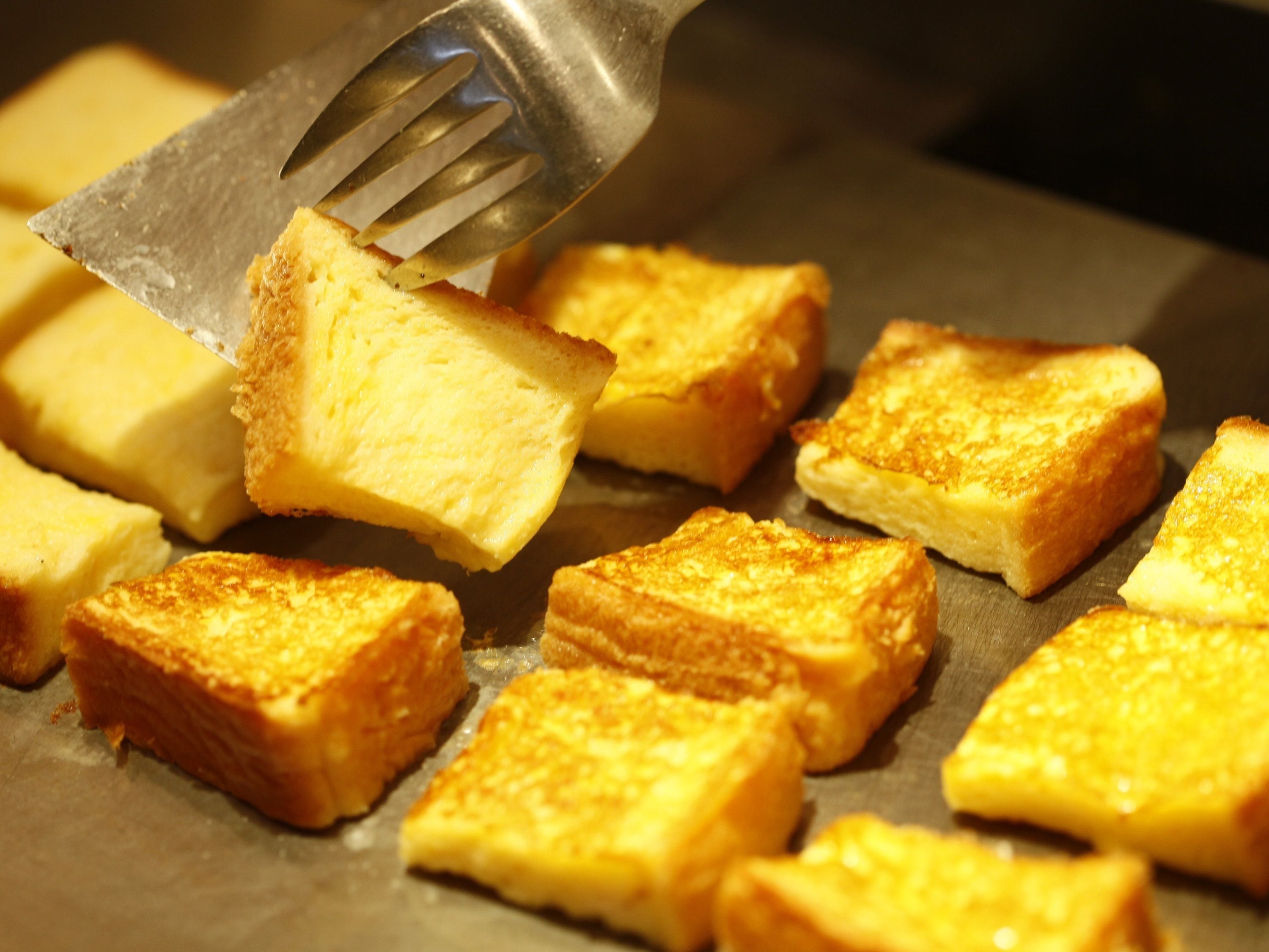 Toasted bread pieces on a griddle.