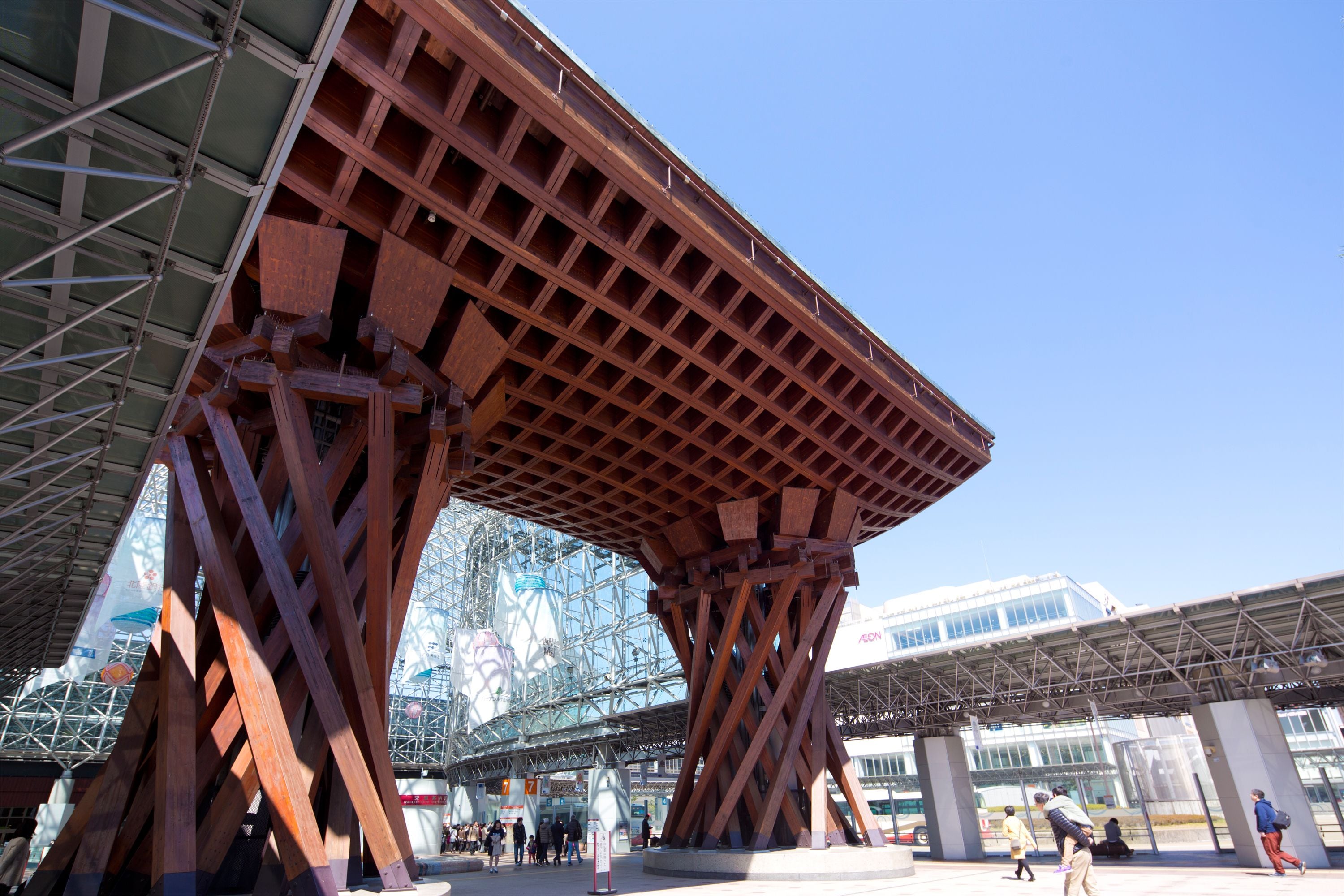Un espacio público amplio y abierto, con una estructura metálica destacada y un edificio de cristal al fondo.