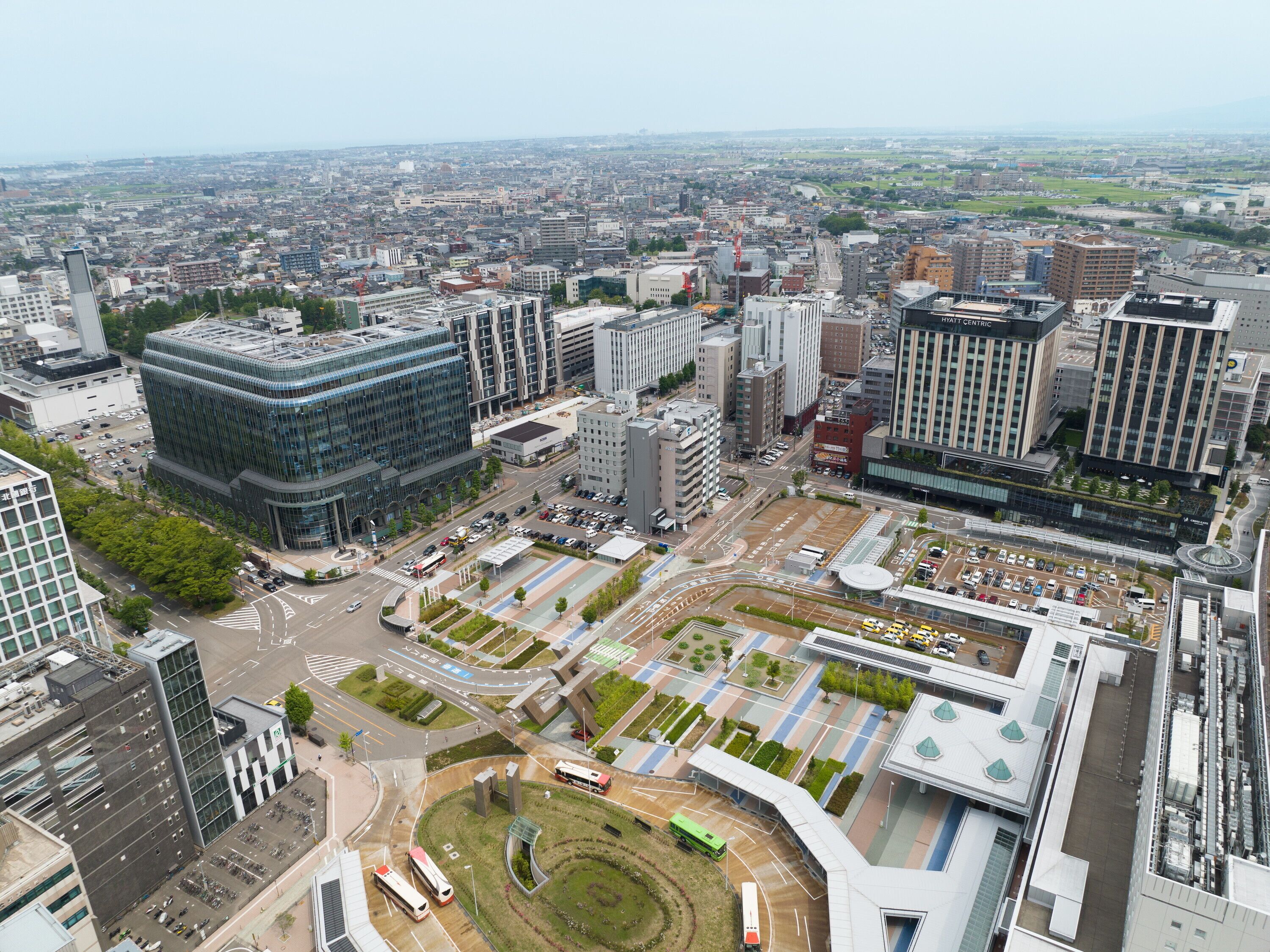 A modern urban area with high-rise buildings, a central roundabout, and a mix of commercial and residential structures.
