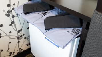 A hotel room with a bed, a nightstand, and a wall with a black and white pattern.
