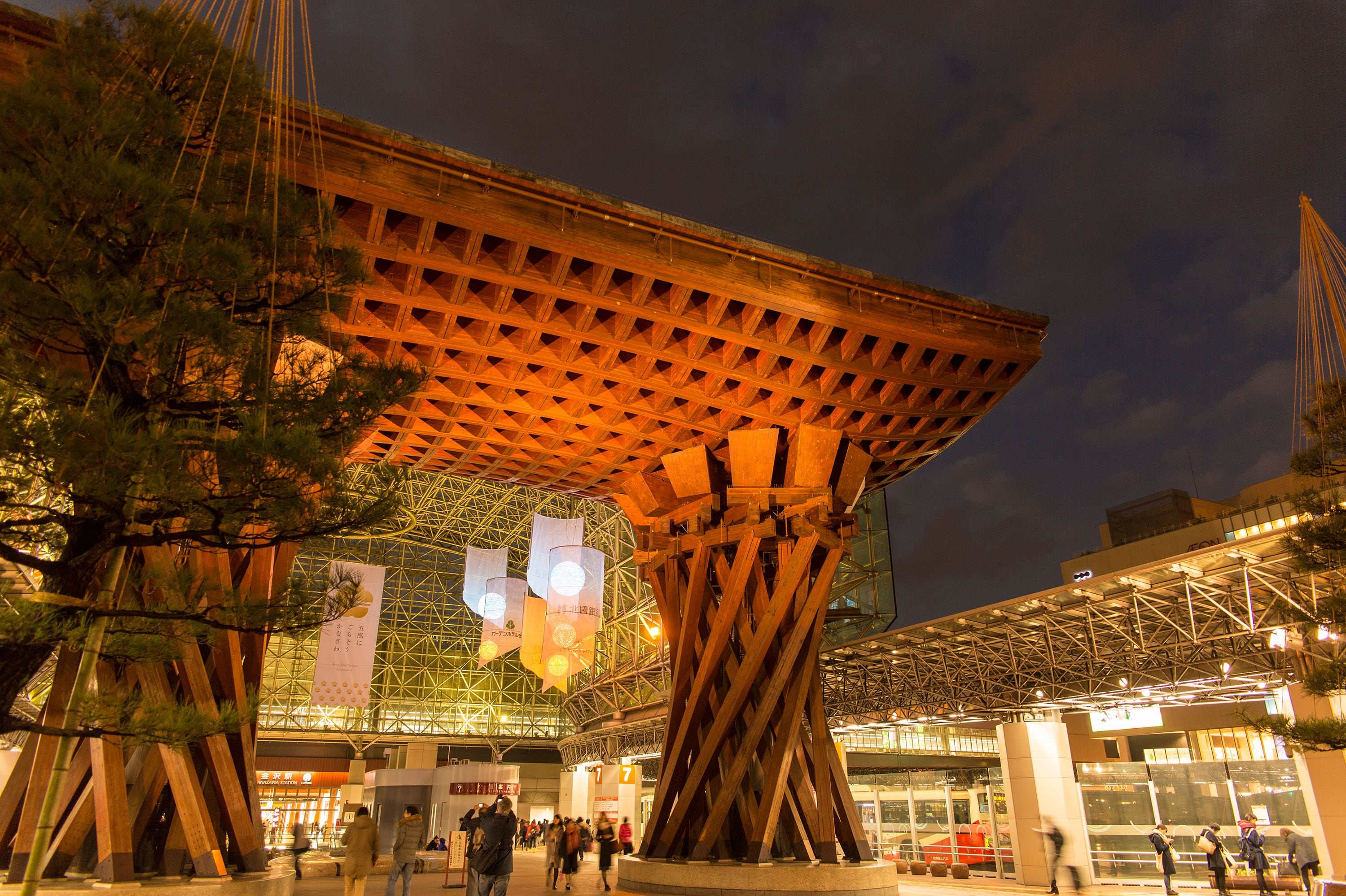 A modern building with a unique wooden structure and a glass facade.