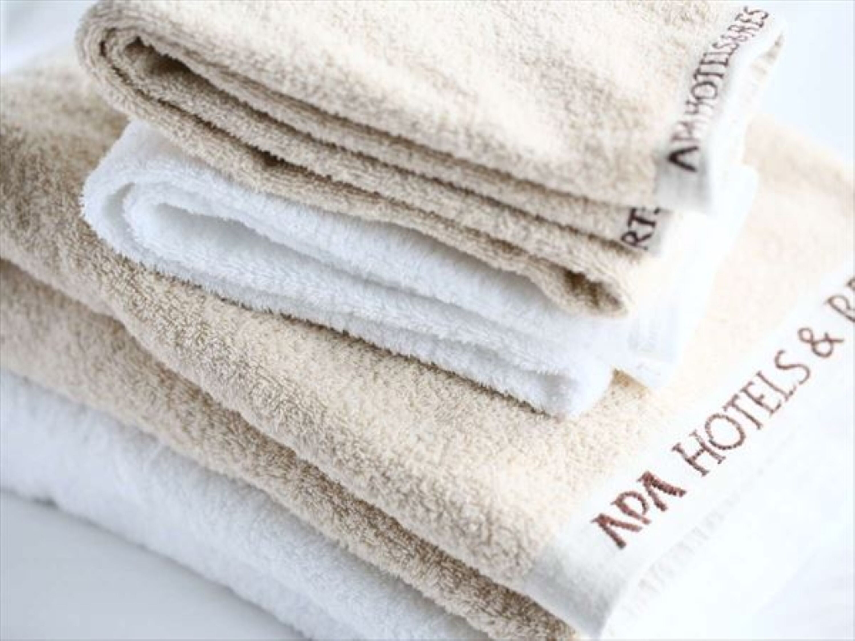 A stack of folded towels with the text "ADA HOTELS & RESORTS" on them.