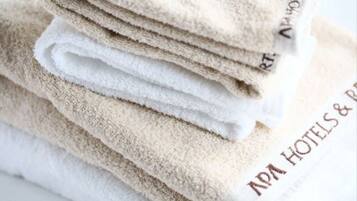A stack of folded towels with the text "ADA HOTELS & RESORTS" on them.
