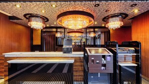 A hotel lobby with a check-in counter, self-service machines, and a chandelier. - APA Hotel Saga Ekimae Chuo (Saga)