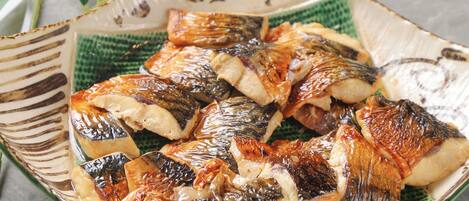 Un plat en céramique contenant du poisson grillé.