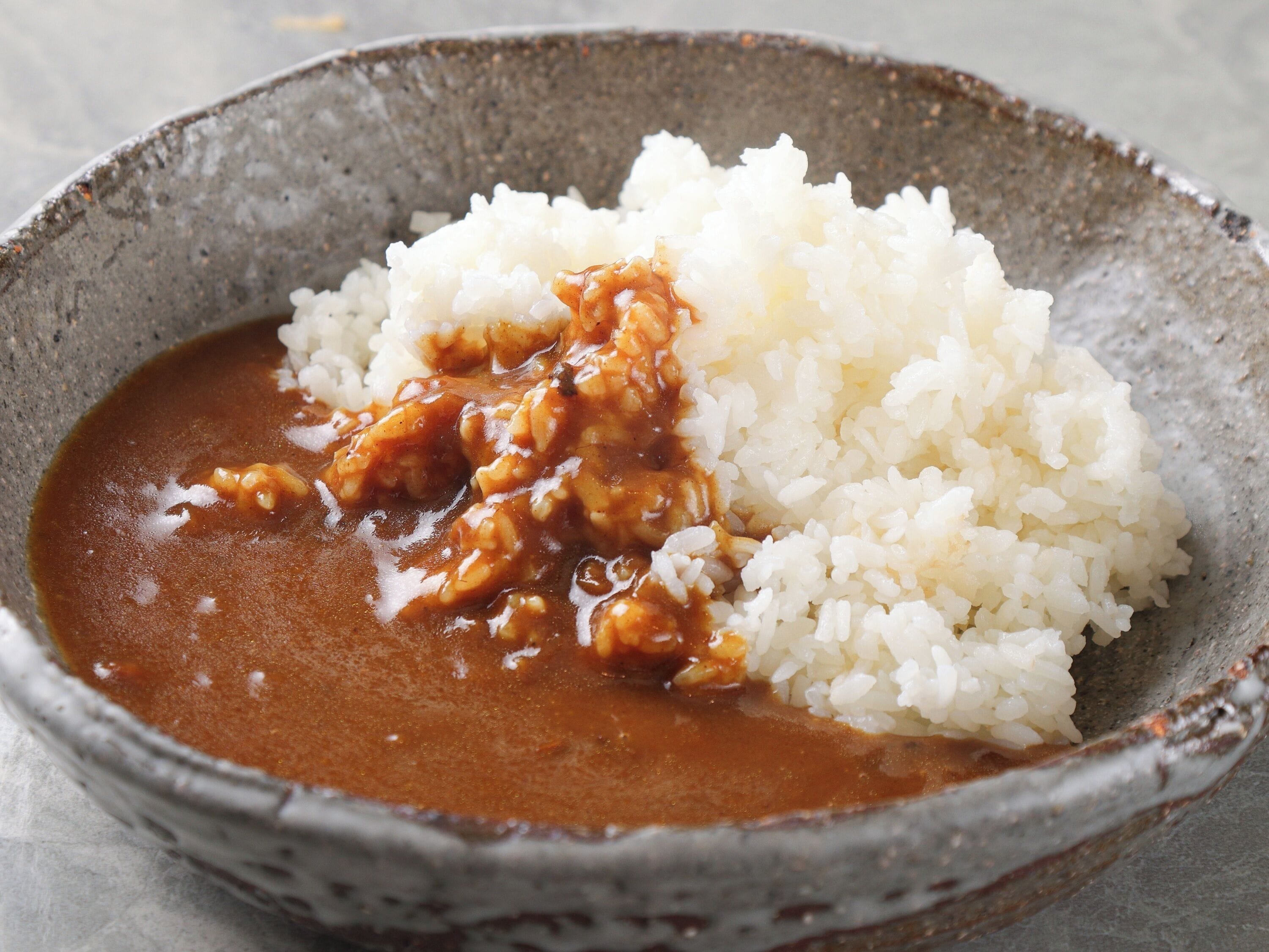 A bowl of white rice with a brown sauce.