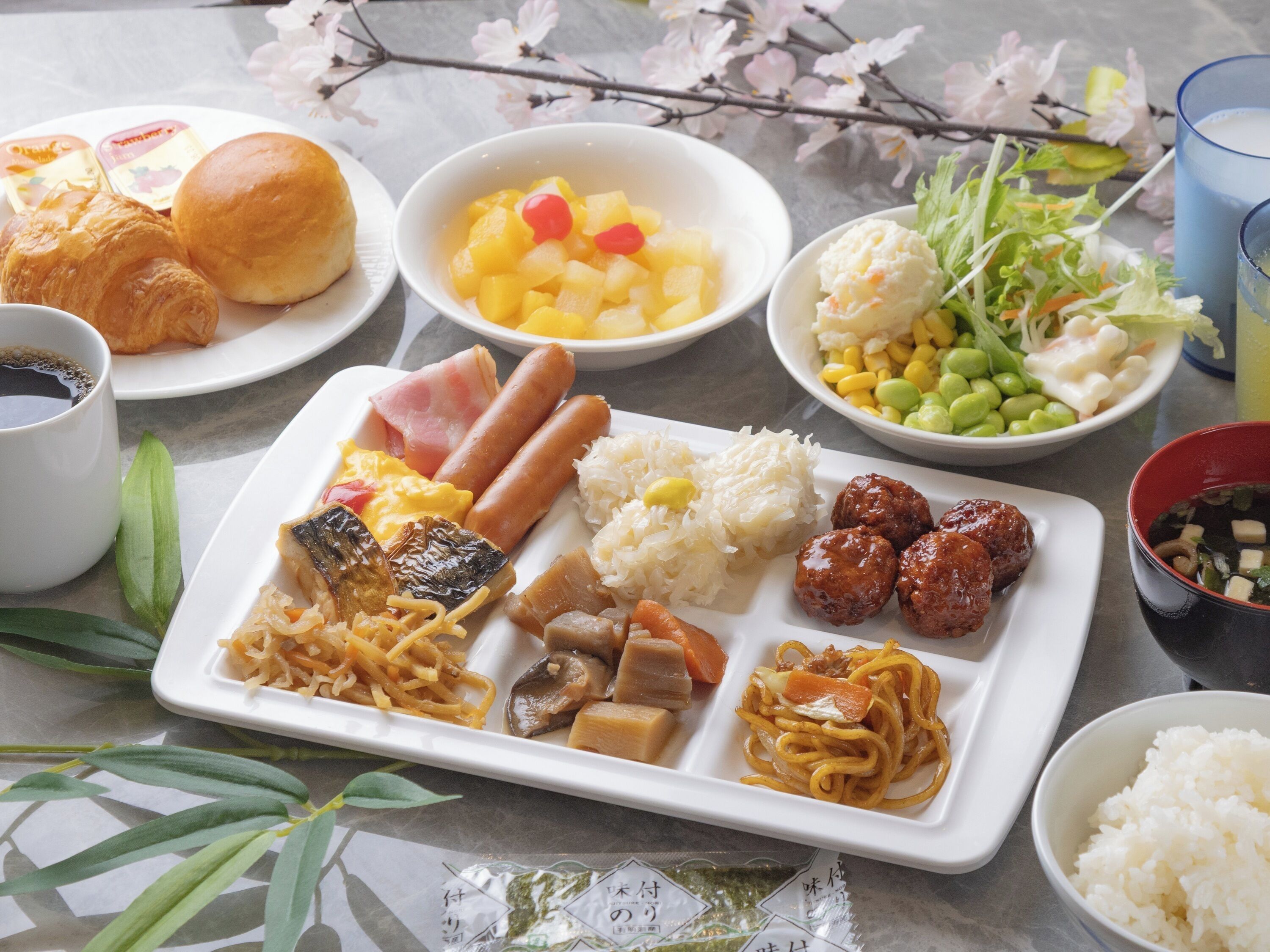 A variety of dishes including sausages, rice, and vegetables on a table.