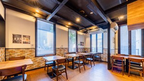L’intérieur d’un restaurant avec des murs en briques, des tables et des chaises en bois.