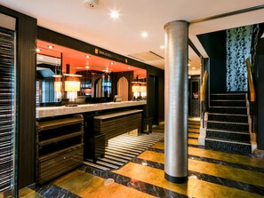 A modern hotel lobby with a reception desk, a large pillar, and a staircase. - APA Hotel Nagasaki Ekimae (Nagasaki)