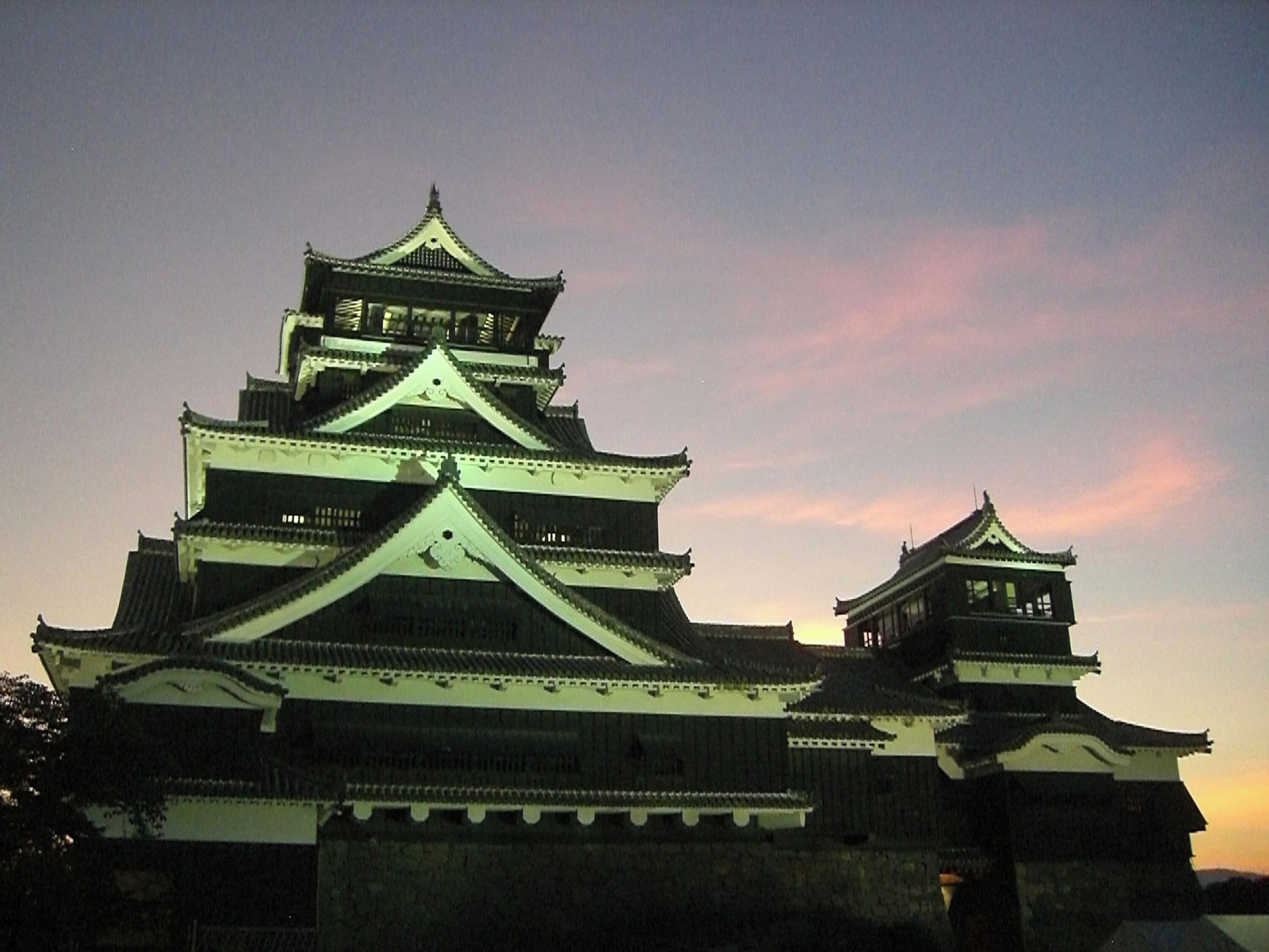 A traditional Japanese castle with multiple tiers and a prominent central tower, surrounded by walls and smaller structures.