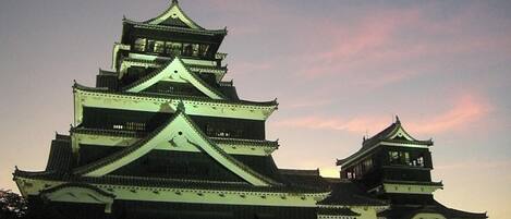 A traditional Japanese castle with multiple tiers and a prominent central tower, surrounded by walls and smaller structures.