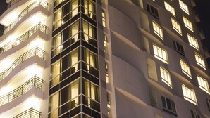 Un edificio de varios pisos con balcones y ventanas iluminadas por la noche.