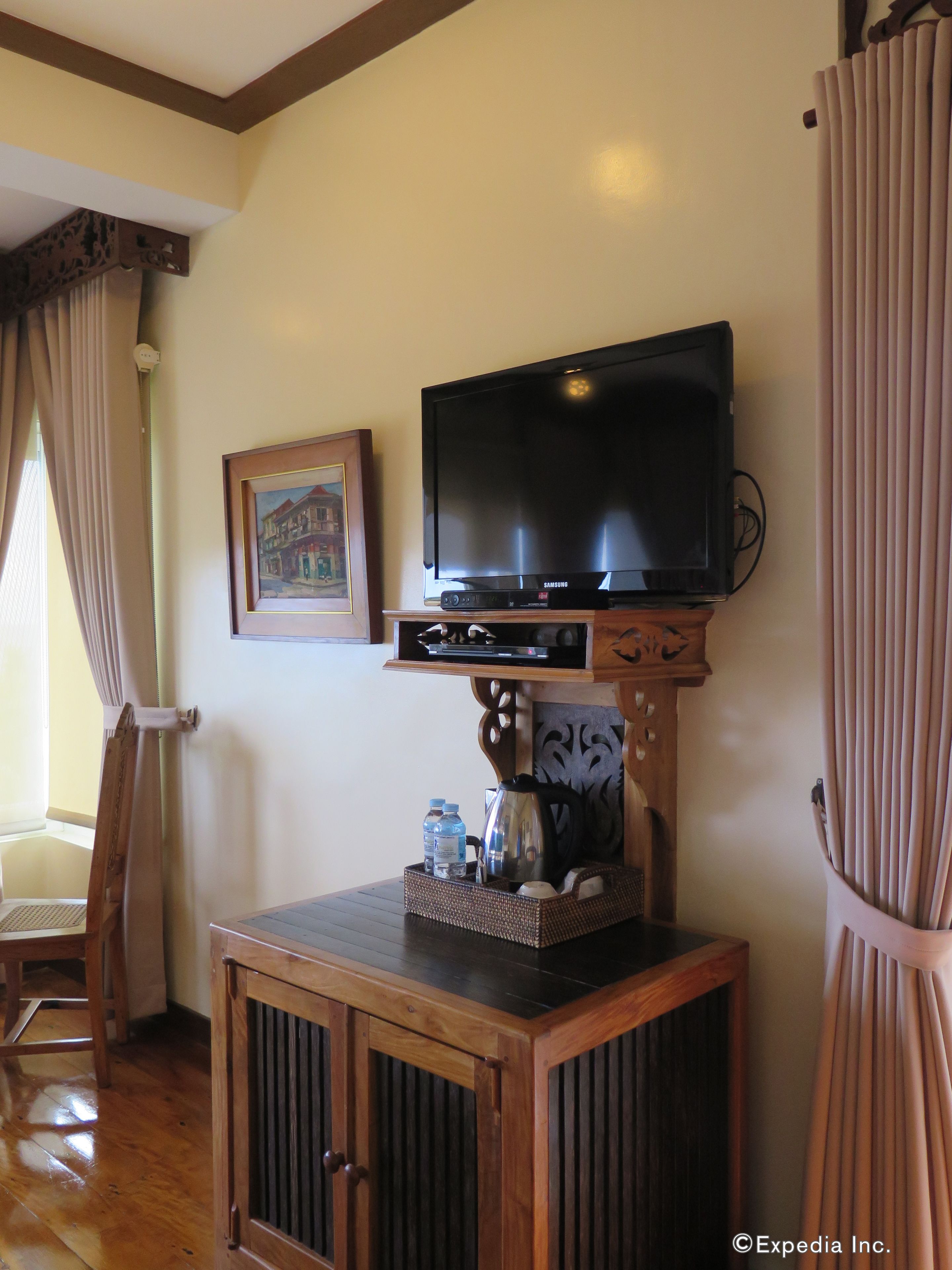 Un televisor montado en un mueble de madera con un marco de fotos encima.