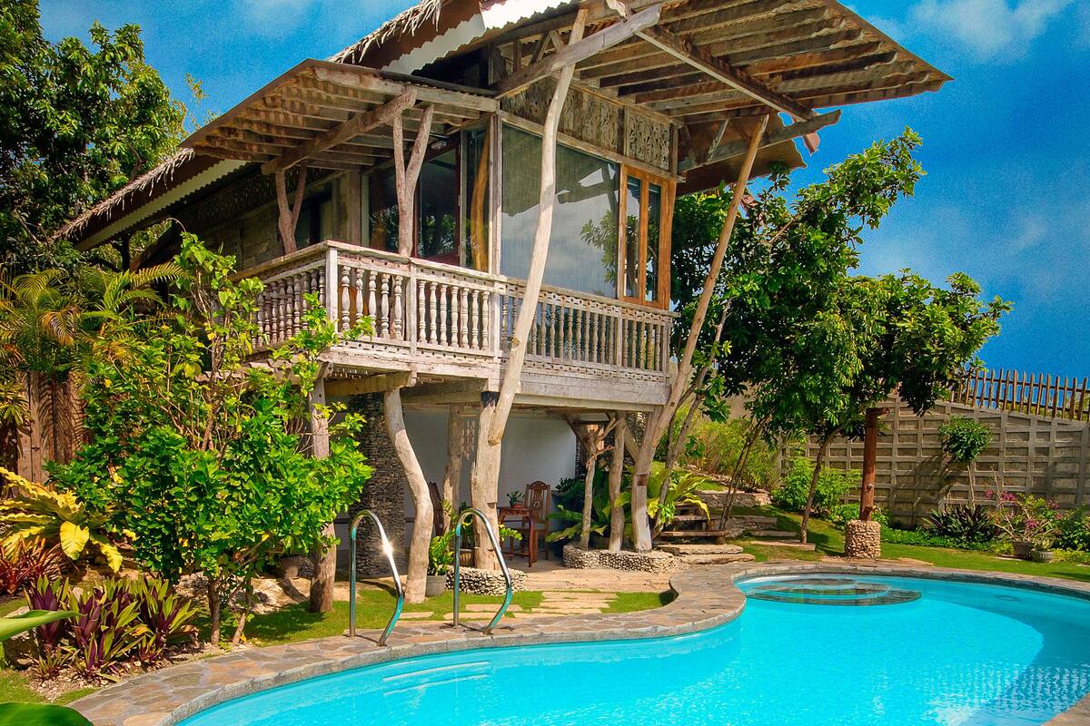 A house with a wooden deck and a swimming pool.