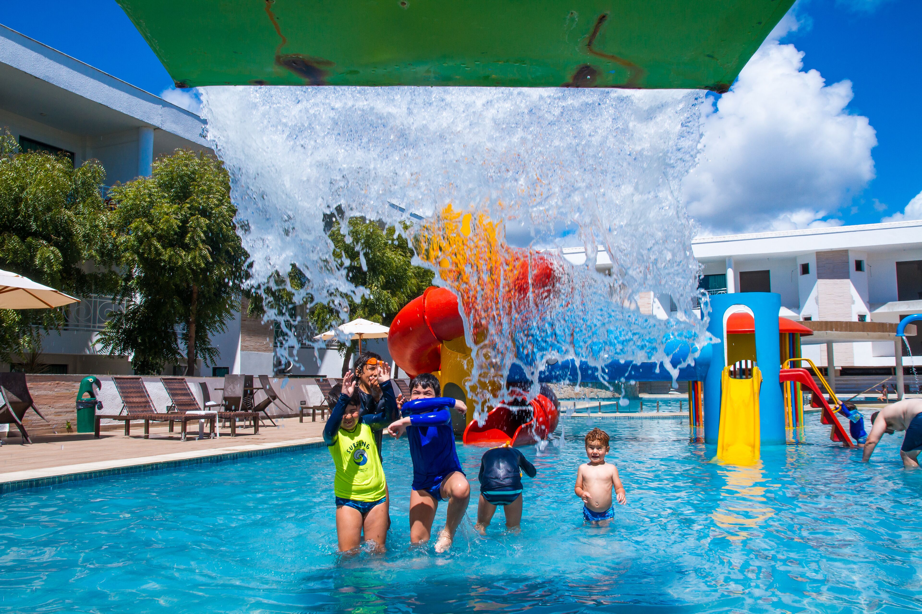 A swimming pool with water slides and lounge chairs.