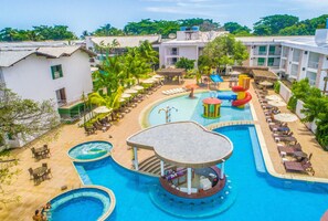 Un resort con varias piscinas, un tobogán de agua y diferentes zonas de descanso.