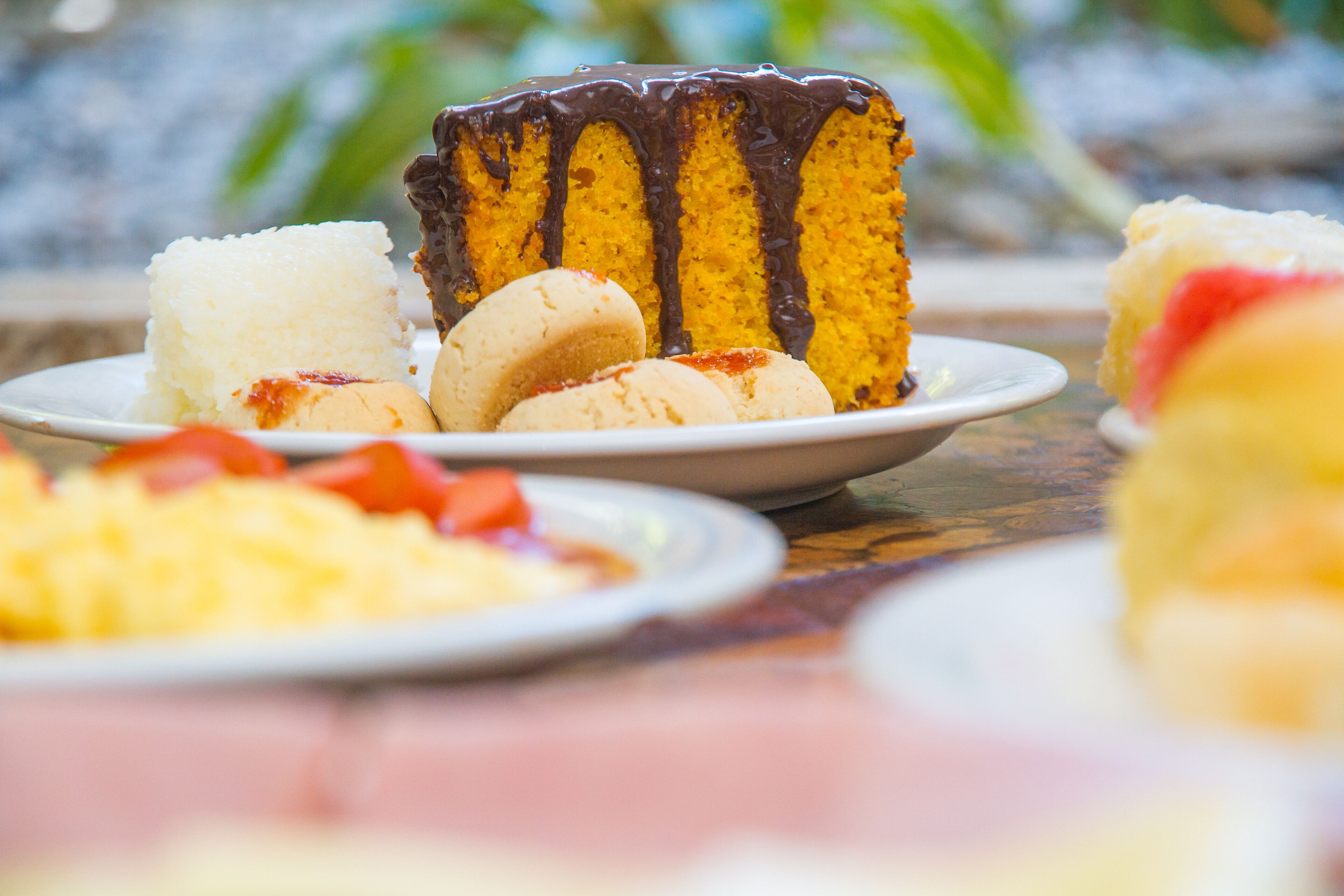 A dessert plate with a slice of yellow cake and white and brown cookies.