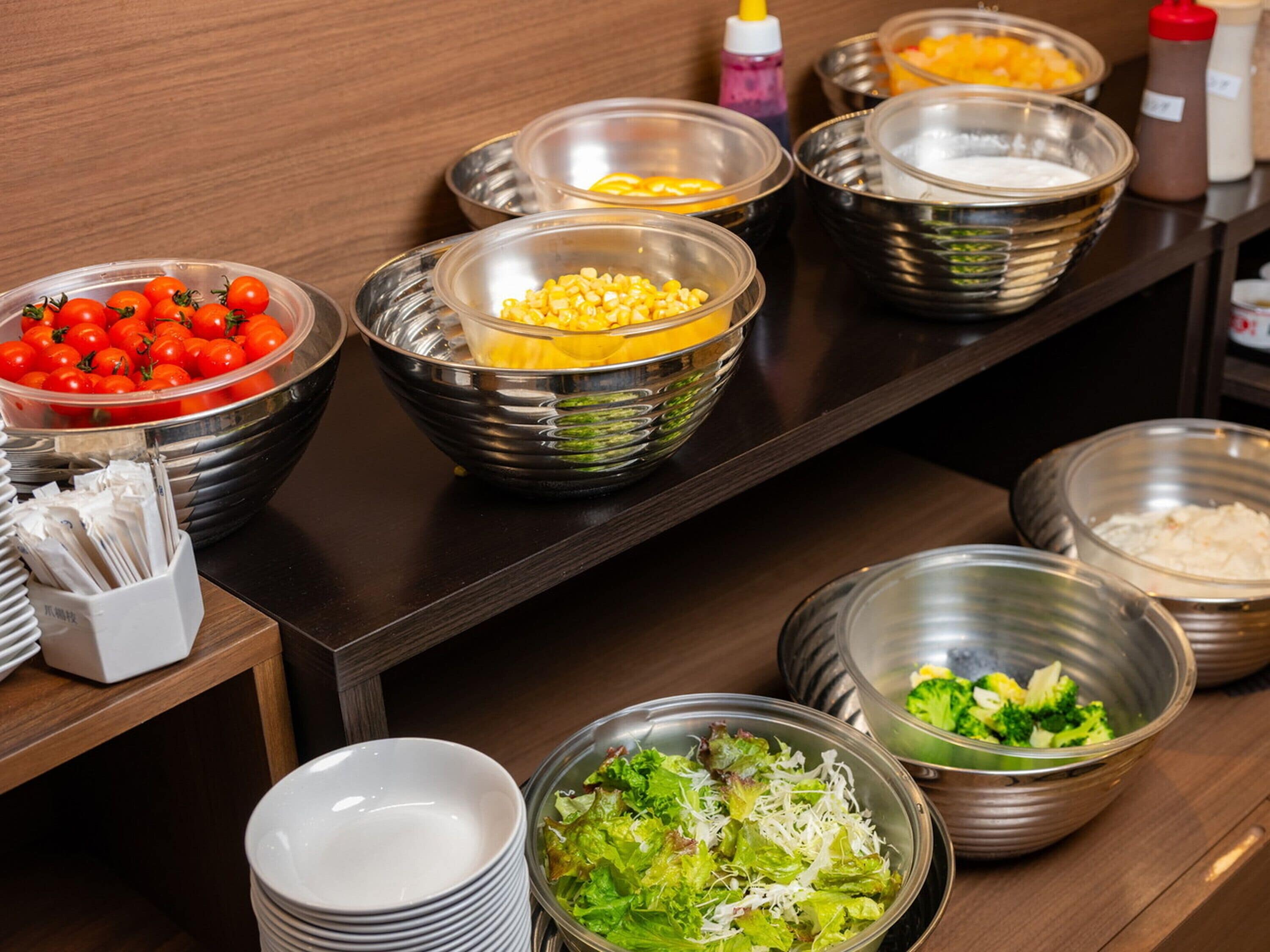 A buffet setup with various food items in bowls.