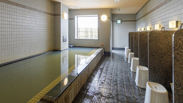 A public restroom with a long bench, tiled walls, and a window. - APA Hotel Nagoya Marunouchi Ekimae (Nagoya)