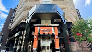 The APA Hotel entrance with a modern design, featuring a prominent orange and black facade, large glass doors, and a clear view of the entrance area. - APA Hotel Kobe Sannomiya (Kobe)
