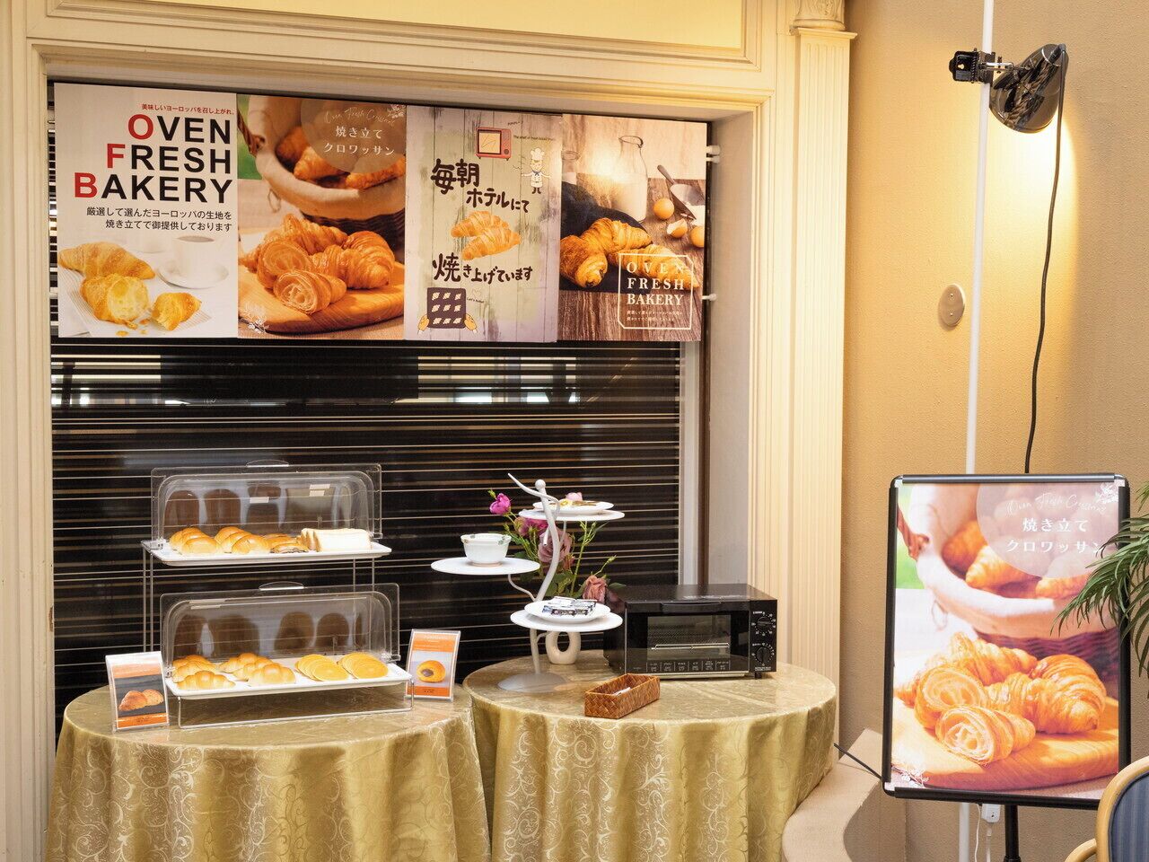 A bakery display with fresh baked goods and a promotional poster.